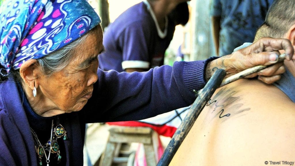 Apo Whang-Od giving a tattoo to a traveler © | Travel Trilogy
