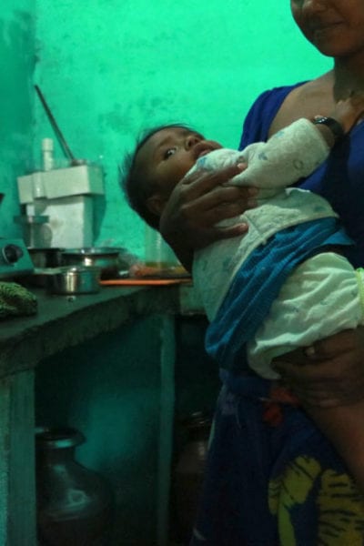 Vera* nurses her young daughter in her kitchen © | Jenna Kunze