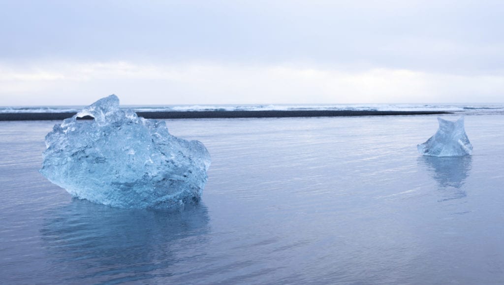 Icebergs from the Jökulsárlón lagoon in Iceland, float past the black sand Diamond Beach | © Jeff Cerulli 