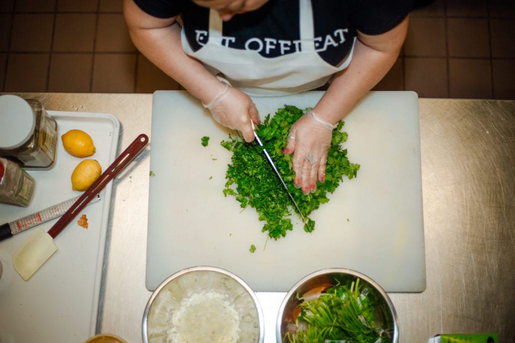 Resettled refugee, Chef Nasrin prepares a dish at the Eat Offbeat kitchen | © Phil Provencio/Unearth Women