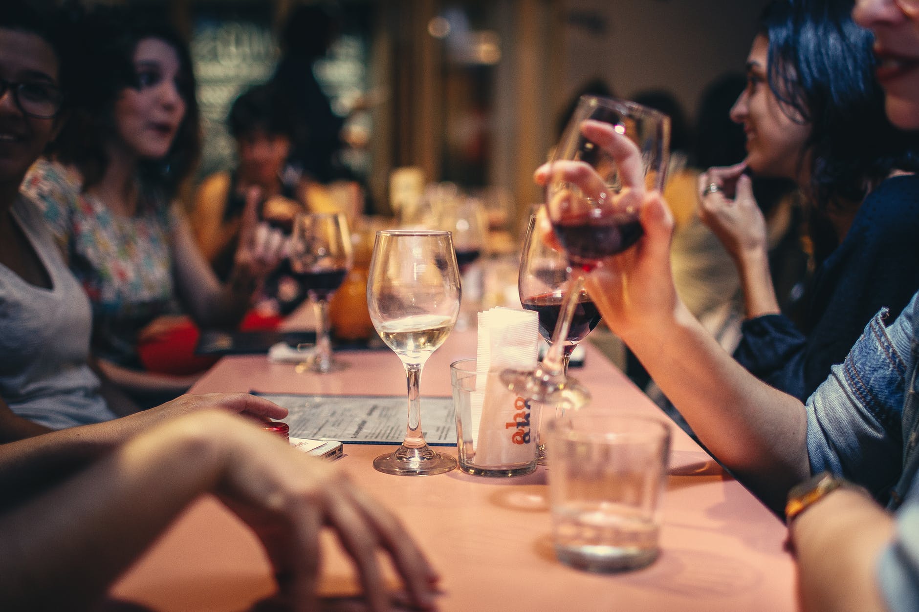 people drinking liquor and talking on dining table close up photo