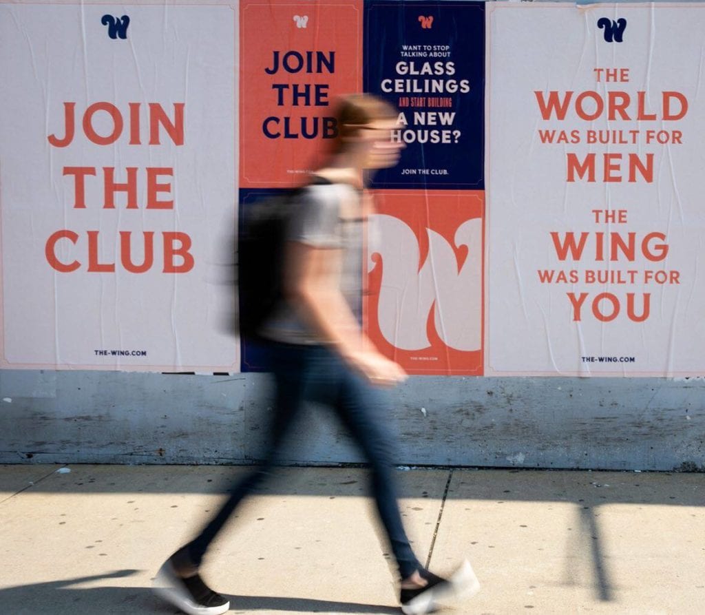 A woman walks past The Wing's ad campaign | © The Wing Facebook Page