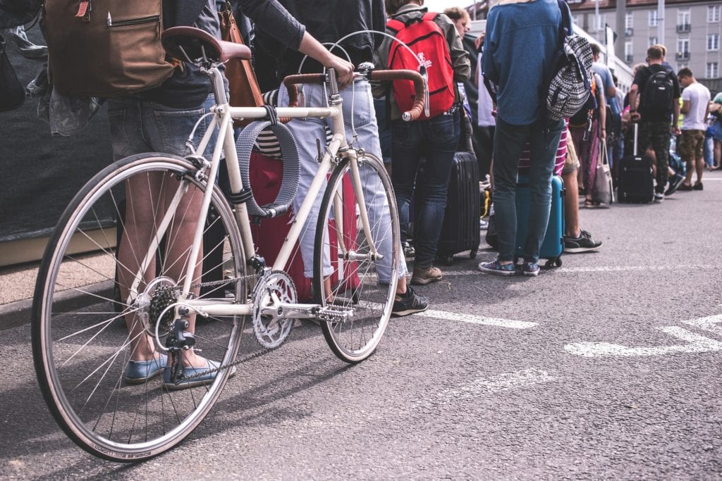 A woman waits in line with her bike | © Snapstock/Pixabay