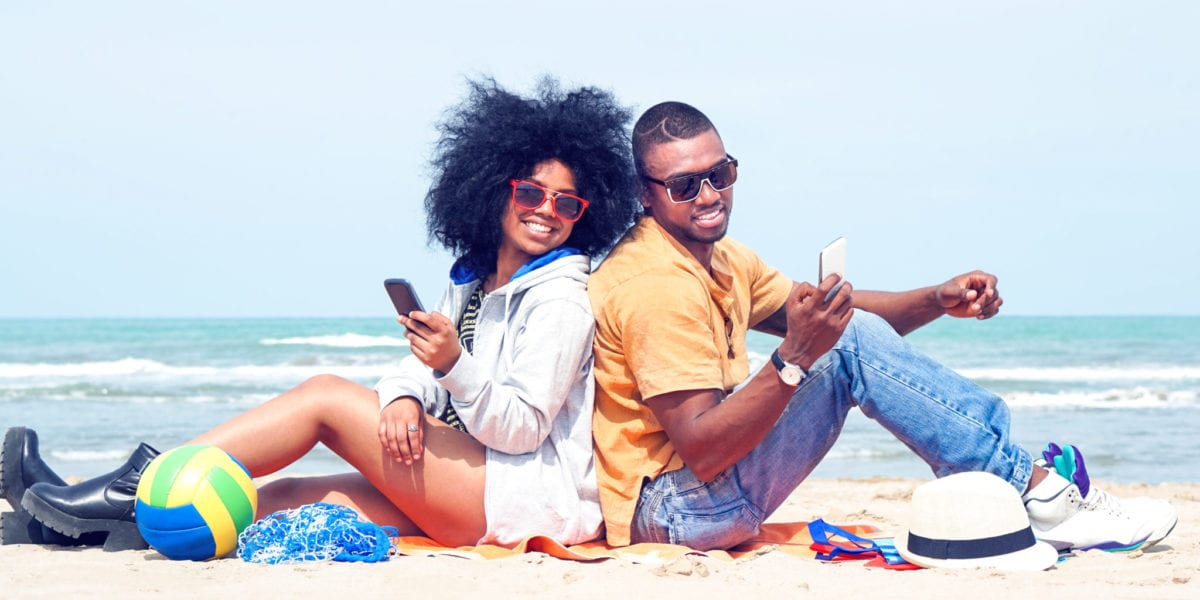 A happy young couple poses on the beach | © Akhenaton Images