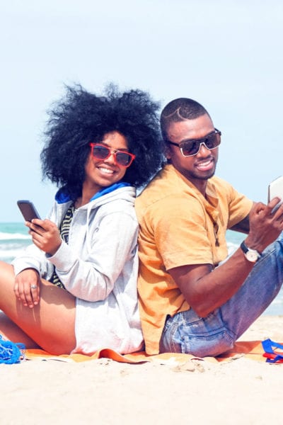 A happy young couple poses on the beach | © Akhenaton Images