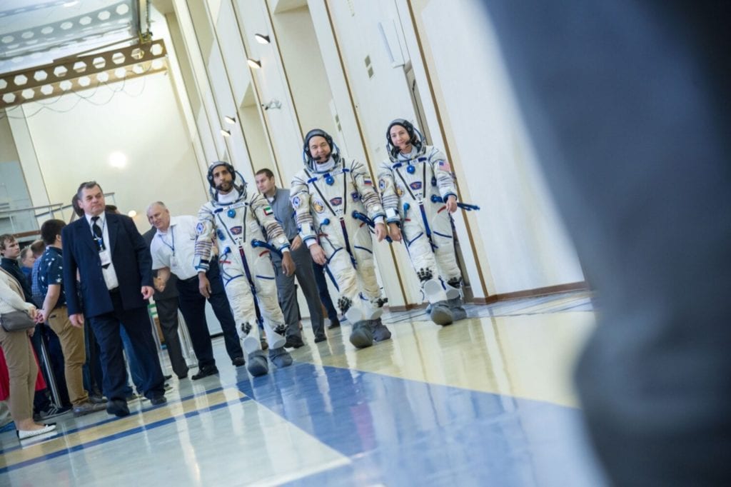 Hazzaa Ali Almansoori of the United Arab Emirates, left, Oleg Skripochka of Roscosmos, center, and Jessica Meir of NASA report for duty | © Mark Sowa/NASA