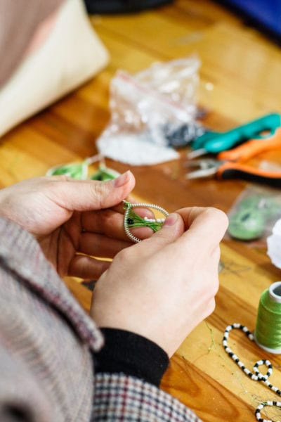 A woman at the Small Projects Istanbul centre in Fatih makes a design of the ‘Drop Earrings Not Bombs’ project | © Annapurna Mellor