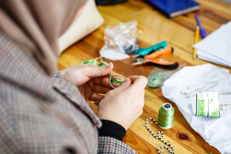 A woman at the Small Projects Istanbul centre in Fatih makes a design of the ‘Drop Earrings Not Bombs’ project | © Annapurna Mellor