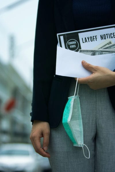 A recently laid off woman holds her severance and lay-off notice | © Shutterstock