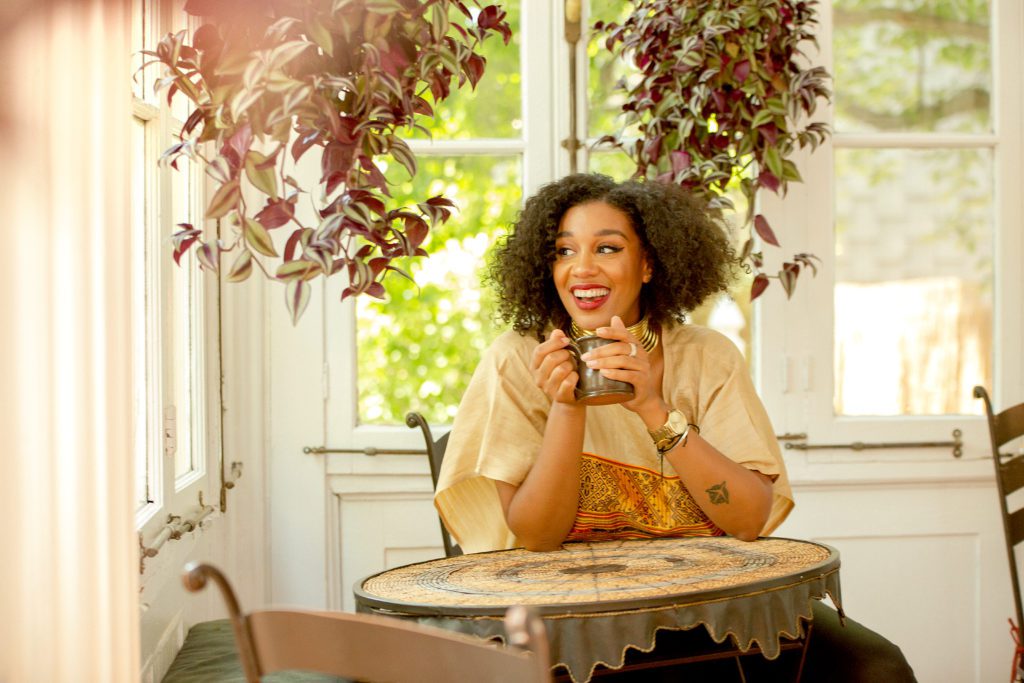 Evita Robinson sits in the sun soaked porch of Akwaaba Mansion © | Phil Provencio/Unearth Women